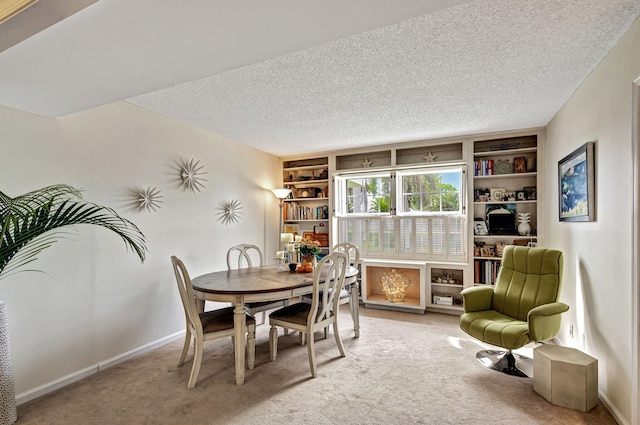 carpeted dining space featuring a textured ceiling and built in features