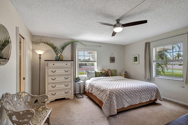 carpeted bedroom featuring a textured ceiling and ceiling fan