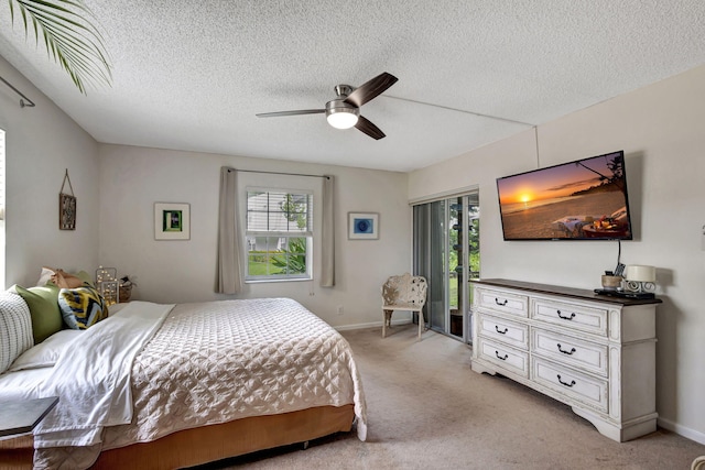 carpeted bedroom featuring a textured ceiling, multiple windows, access to outside, and ceiling fan