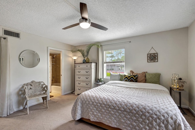 bedroom with connected bathroom, ceiling fan, light carpet, and a textured ceiling