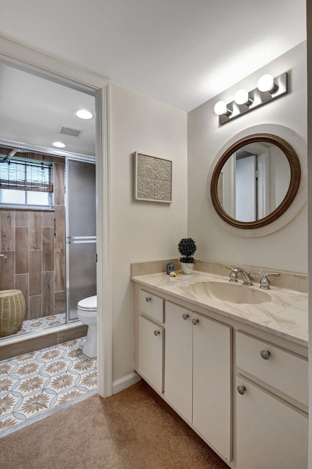 bathroom with vanity, a shower with shower door, toilet, and tile patterned floors