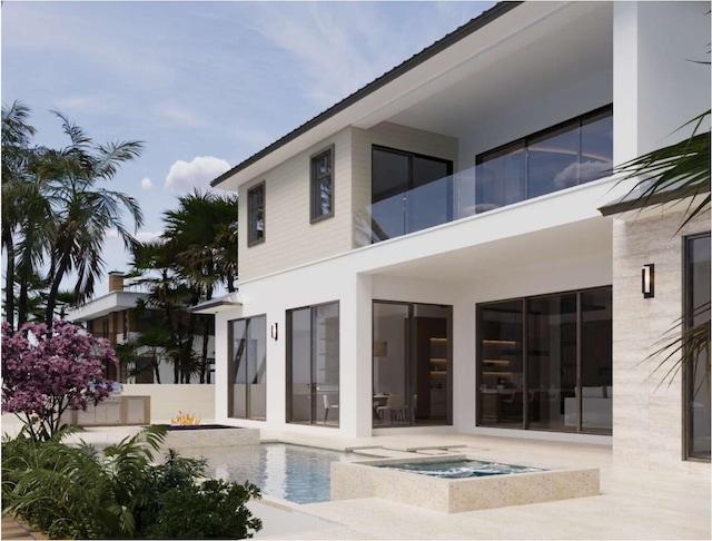 rear view of house featuring a patio area and an in ground hot tub