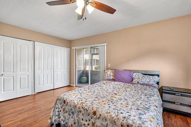 bedroom with two closets, wood-type flooring, and ceiling fan