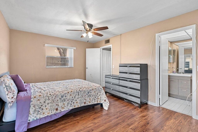 bedroom with connected bathroom, wood-type flooring, and ceiling fan