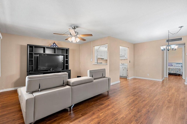 living room featuring hardwood / wood-style flooring and ceiling fan with notable chandelier