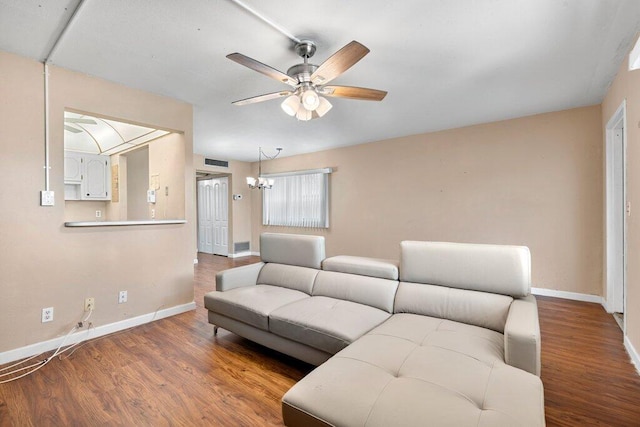 living room featuring ceiling fan with notable chandelier and hardwood / wood-style floors