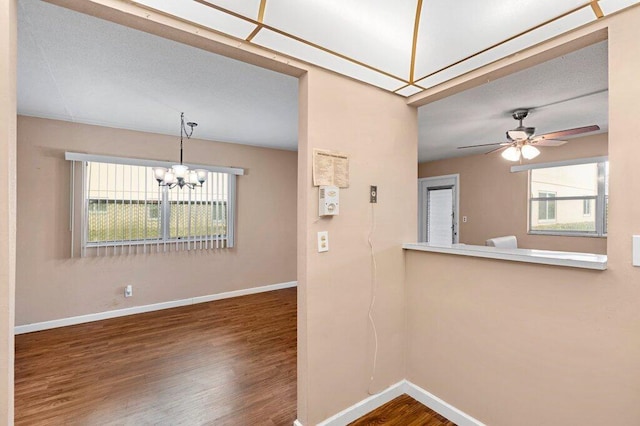 spare room with ceiling fan with notable chandelier and hardwood / wood-style floors