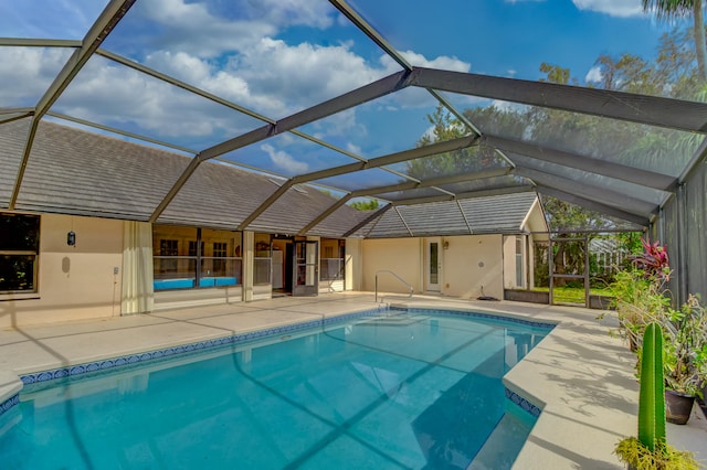 view of swimming pool with glass enclosure and a patio area