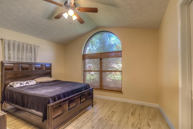 1138 SW Greenbriar Cv, Port Saint Lucie, FL 34986 - bedroom with a textured ceiling, wood finished floors, lofted ceiling, baseboards, and ceiling fan