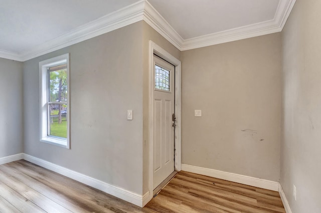 entryway with a wealth of natural light, crown molding, and light hardwood / wood-style flooring