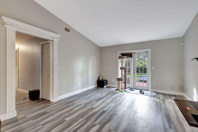 spare room with light hardwood / wood-style floors and lofted ceiling