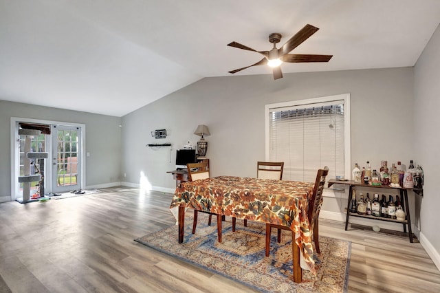 dining room featuring light wood-type flooring, lofted ceiling, and ceiling fan