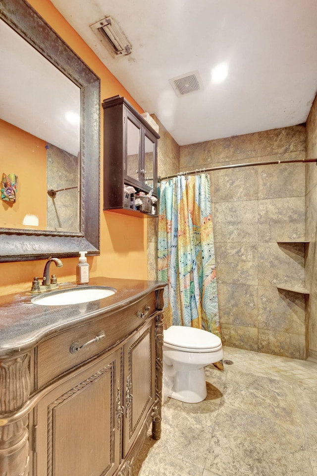 bathroom with walk in shower, vanity, and toilet