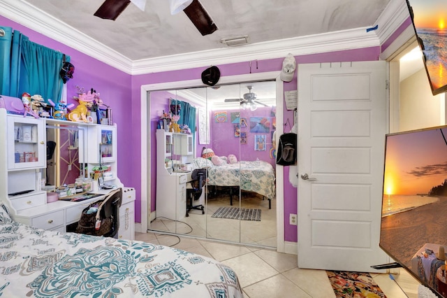 tiled bedroom featuring ceiling fan, crown molding, and a closet