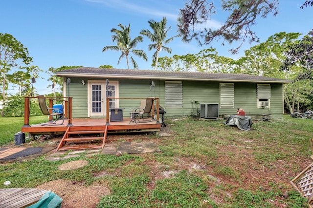 rear view of property featuring cooling unit, a yard, and a deck