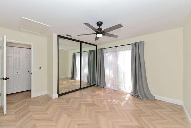 unfurnished bedroom with ceiling fan, light parquet floors, and a closet