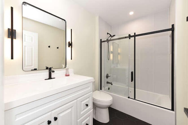 full bathroom with tile patterned floors, shower / bath combination with glass door, vanity, and toilet