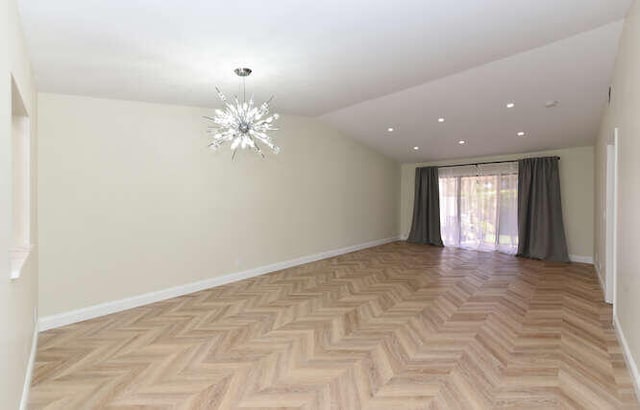 spare room featuring an inviting chandelier, vaulted ceiling, and light parquet flooring