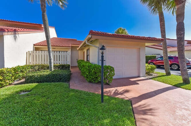 mediterranean / spanish house with a garage and a front yard