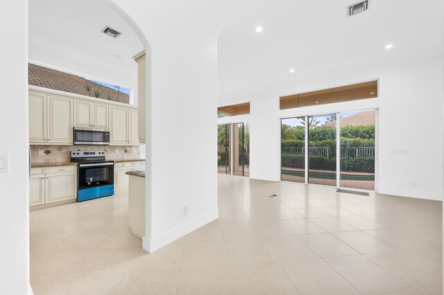 kitchen with backsplash, appliances with stainless steel finishes, light tile patterned floors, and cream cabinets