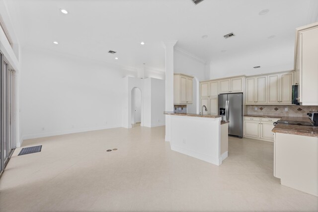 kitchen with tasteful backsplash, sink, cream cabinetry, crown molding, and stainless steel fridge with ice dispenser