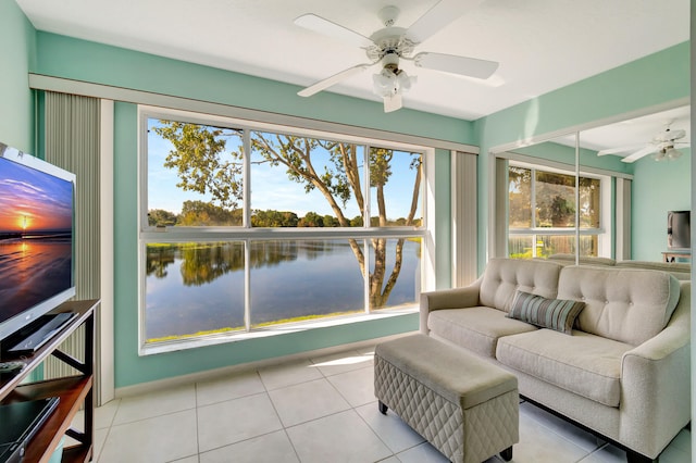 sunroom / solarium with a water view and ceiling fan