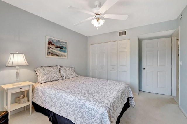 carpeted bedroom with ceiling fan and a closet