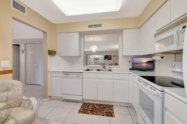 kitchen with white cabinets, white appliances, sink, hanging light fixtures, and light tile patterned floors