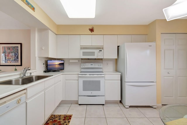 kitchen with light tile patterned flooring, white appliances, white cabinets, and sink