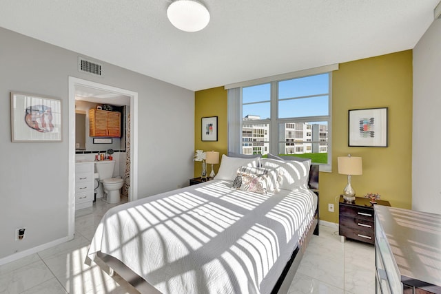 bedroom featuring a textured ceiling and ensuite bathroom