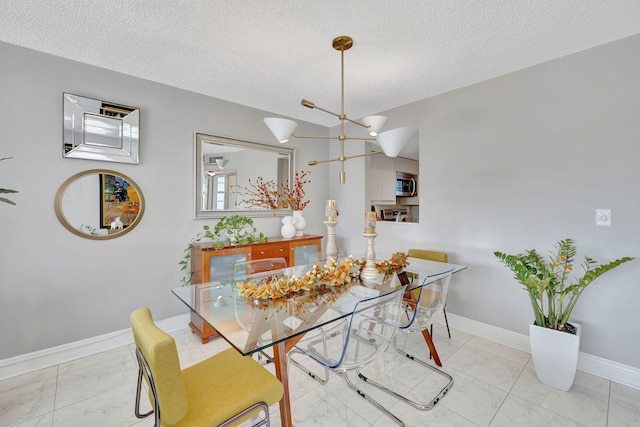 dining area with a chandelier and a textured ceiling