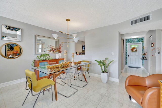 1480 NW 80th Ave Unit 201, Margate, FL 33063 - dining room featuring light marble finish floors, a textured ceiling, and baseboards