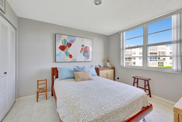 1480 NW 80th Ave Unit 201, Margate, FL 33063 - bedroom with light marble finish flooring, a closet, a textured ceiling, and baseboards