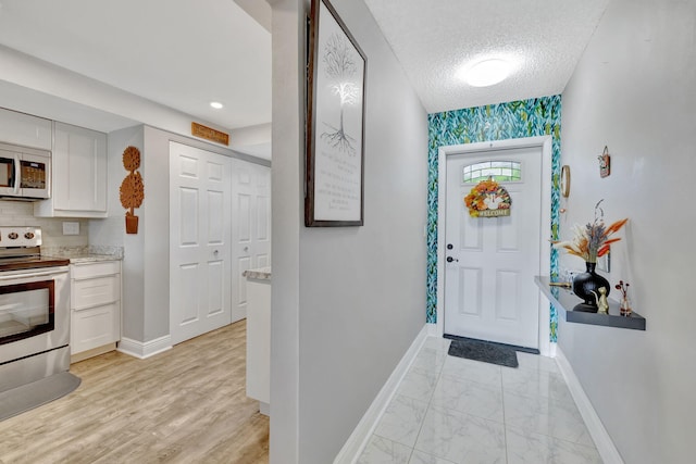 1480 NW 80th Ave Unit 201, Margate, FL 33063 - foyer featuring baseboards, a textured ceiling, and light marble finish flooring