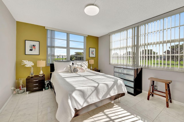 1480 NW 80th Ave Unit 201, Margate, FL 33063 - bedroom with marble look tile flooring, baseboards, and a textured ceiling