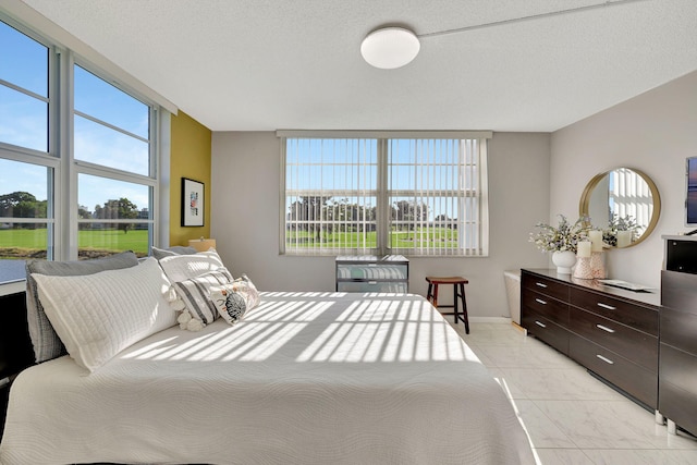 bedroom with a textured ceiling and light tile patterned floors