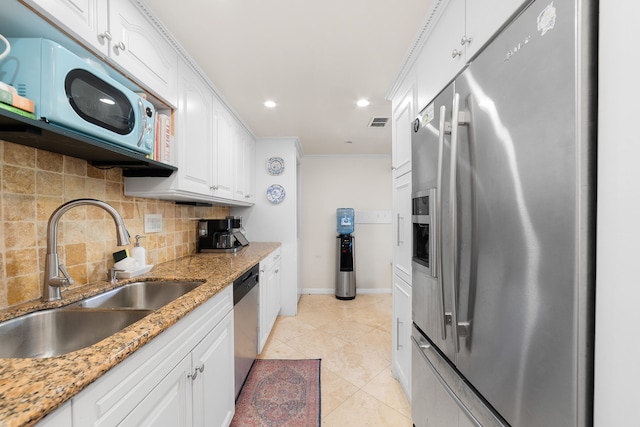 kitchen with sink, appliances with stainless steel finishes, light stone counters, and white cabinetry