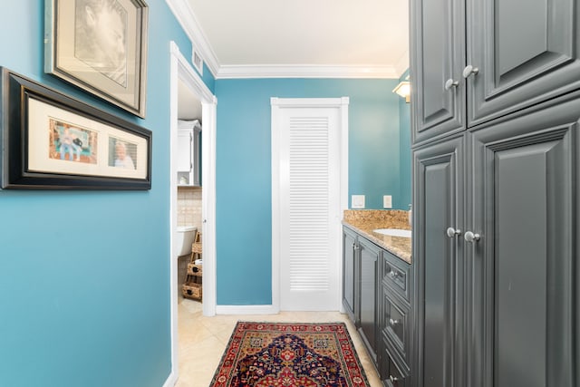 bathroom featuring vanity, toilet, tile patterned floors, and ornamental molding