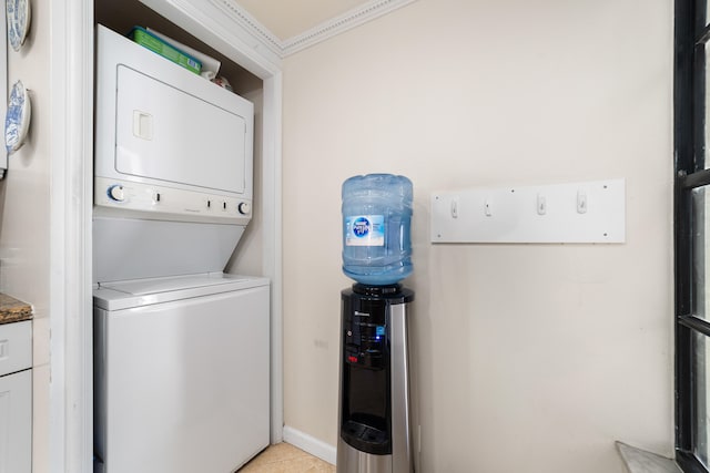 washroom featuring crown molding and stacked washer and dryer