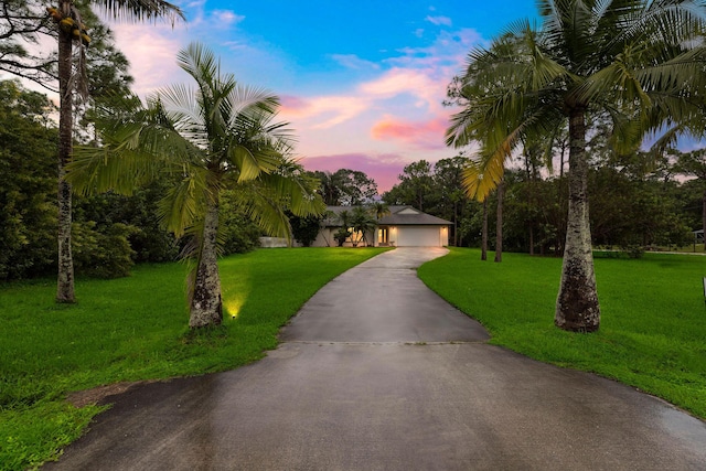 view of front of house with a garage and a lawn