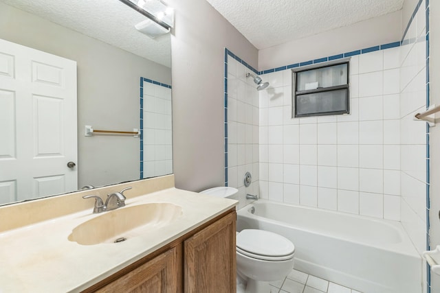 full bathroom featuring toilet, tile patterned floors, tiled shower / bath, vanity, and a textured ceiling