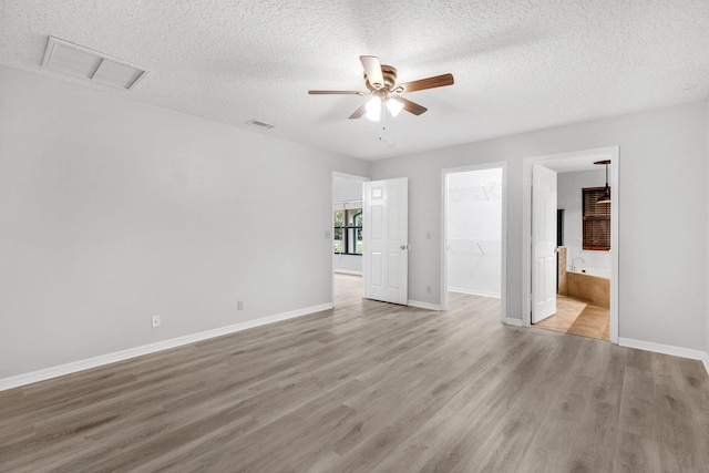 spare room with a textured ceiling, light wood-type flooring, and ceiling fan