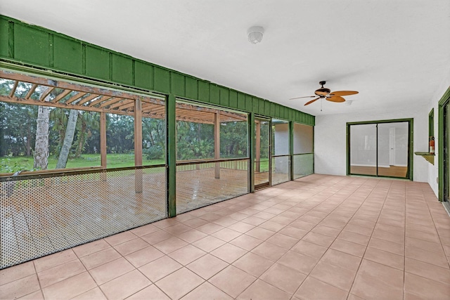 unfurnished sunroom featuring ceiling fan