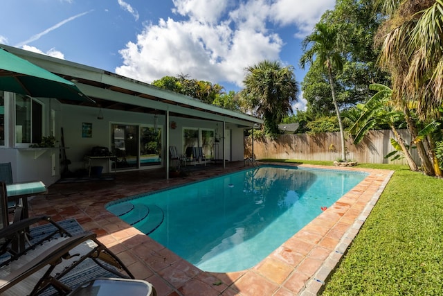 view of swimming pool featuring a yard and a patio area