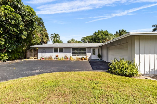 single story home with a garage and a front lawn