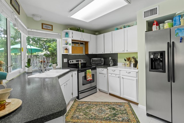 kitchen featuring stainless steel appliances, white cabinets, sink, and decorative backsplash