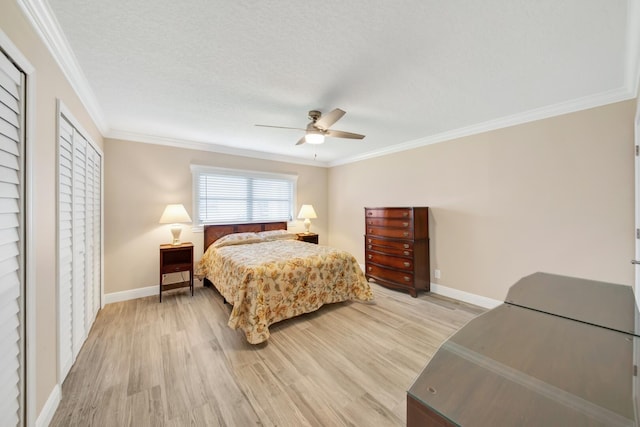 bedroom featuring light wood-type flooring, a textured ceiling, ceiling fan, and crown molding