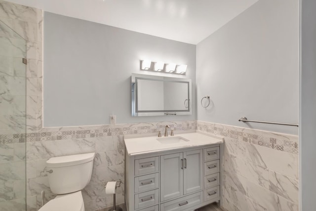 bathroom featuring vanity, toilet, and tile walls