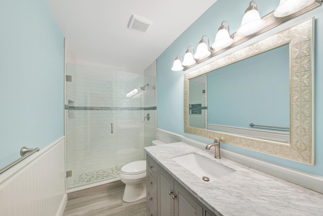 bathroom featuring toilet, an enclosed shower, vanity, and hardwood / wood-style flooring