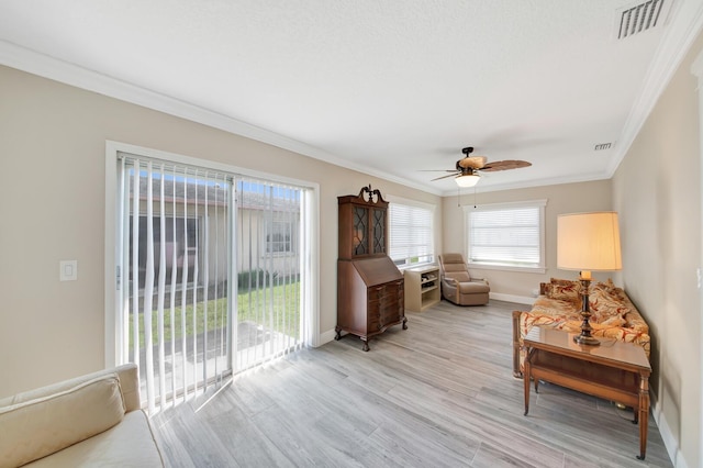 sitting room featuring light wood-type flooring, ceiling fan, and crown molding